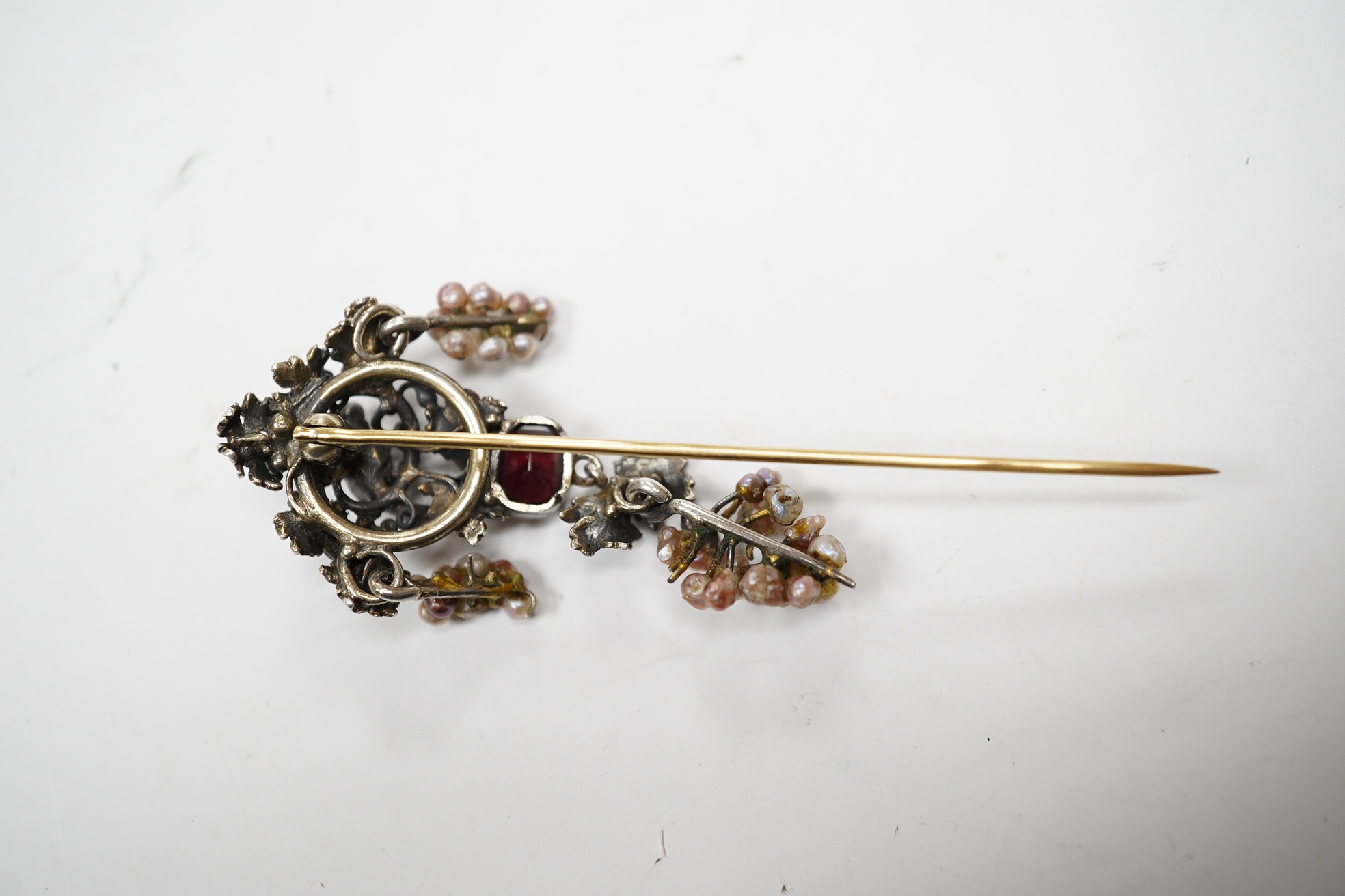 A 19th century Austro-Hungarian? gilt white metal, baroque pearl enamel and garnet set drop stick pin, decorated with birds and fruiting vines, 73mm. Condition - poor.